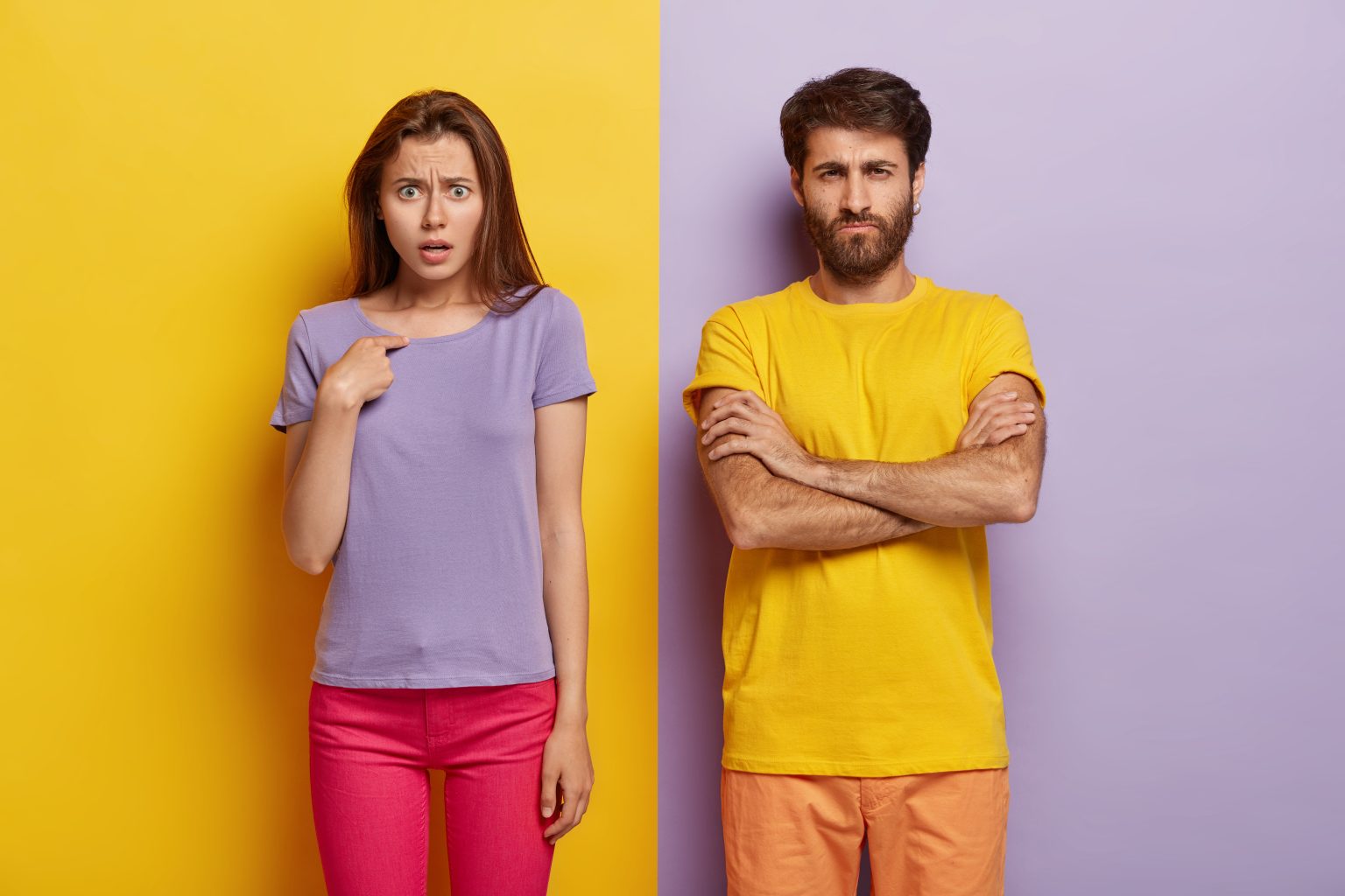 dissatisfied sullen unshaven guy keeps arms folded indignant young woman points herself
