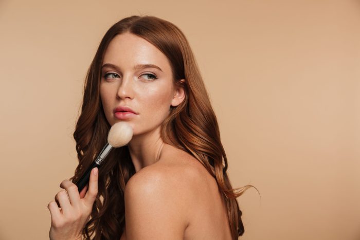 beauty portrait sensual ginger woman with long hair posing sideways while looking away holding cosmetics brush scaled e1699955552730